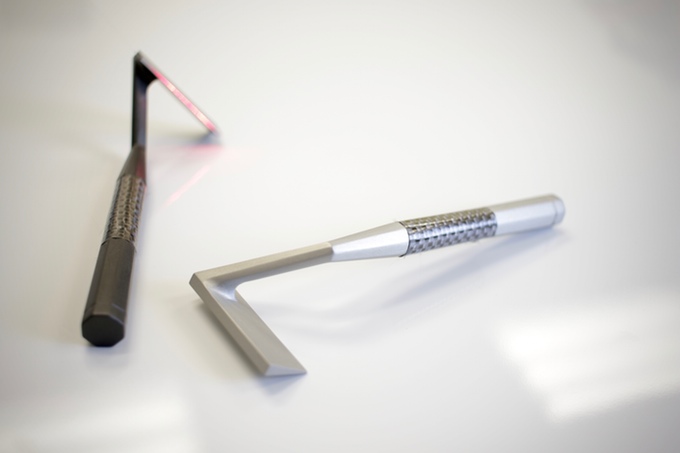 Two of the aluminum prototypes with the laser turned on